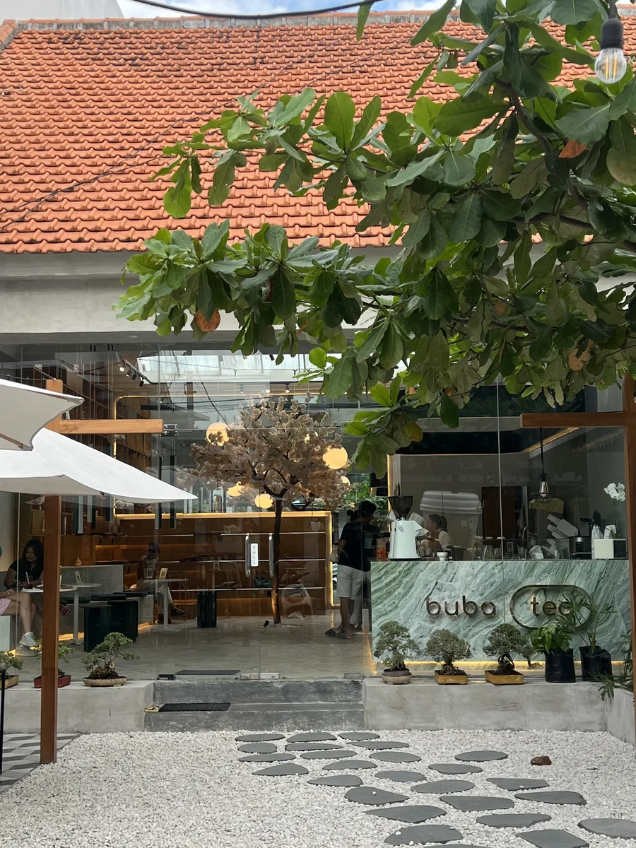 The entrance seen from the courtyard, with the green marble counter and bonsai